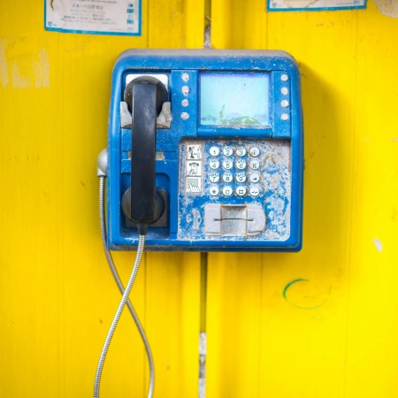 Pay phone on a yellow wall