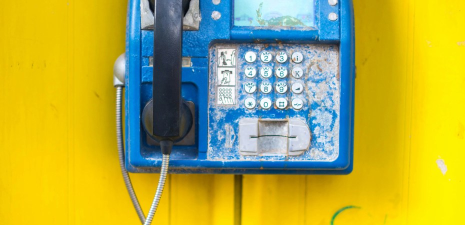 Pay phone on a yellow wall