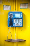 Pay phone on a yellow wall